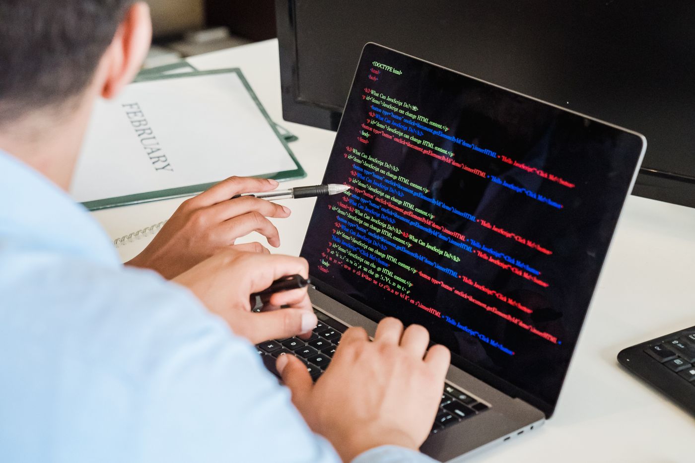 Dizüstü bilgisayarda yazılım kodu yazan kişi – Açık Kaynak E-Ticaret Yazılımı Nedir? Avantajları ve Seçim Kriterleri
