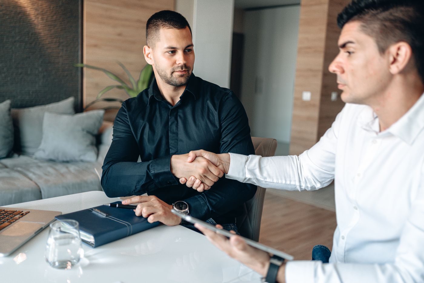 Ofiste anlaşmayı el sıkışarak tamamlayan iki iş insanı – B2B E-Ticaret Rehberi: Bayi Sipariş Sistemi Nasıl Kurulur?