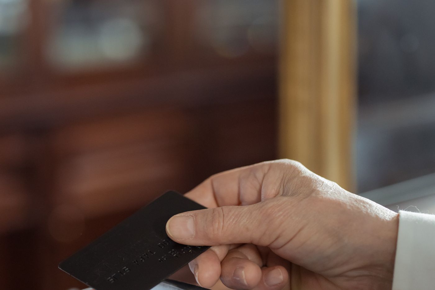 Kredi kartını ödeme terminalinin üzerinde tutan el – E-Ticarette Ödeme Altyapısı: Sanal POS Seçenekleri ve Entegrasyon