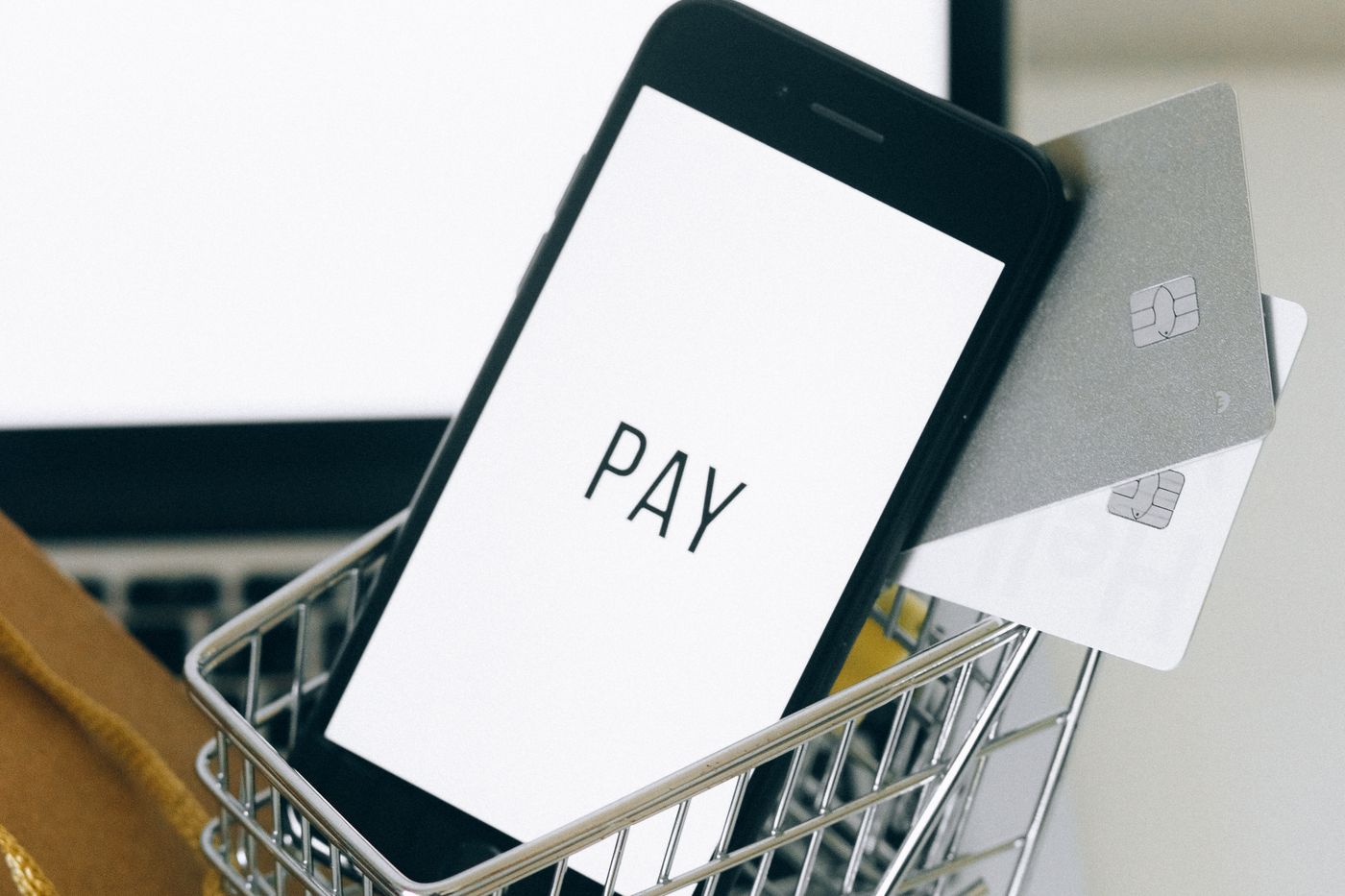 Alışveriş arabasının içinde duran akıllı telefon – Mobil Uygulamalı E-Ticaret: Ne Zaman Gerekir, Maliyeti Nedir?